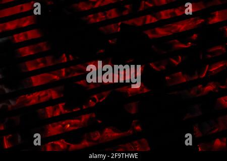 Burning coals on a grill. Black and red background. Stock Photo