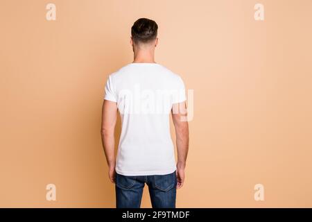 Back rear view photo of young brown hair man avoiding incognito anonym isolated over beige color background Stock Photo