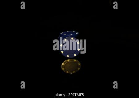 Blue chips stack with a blue chip in front isolated on black with reflection Stock Photo