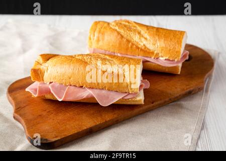 Homemade Parisian Jambon-Beurre Sandwich on a rustic wooden board, side view. Stock Photo