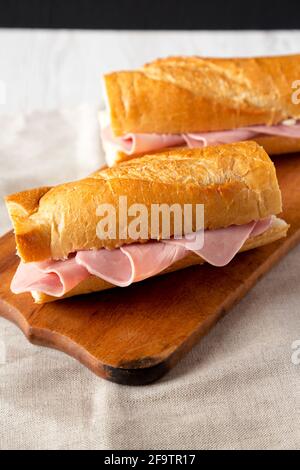 Homemade Parisian Jambon-Beurre Sandwich on a rustic wooden board, side view. Stock Photo