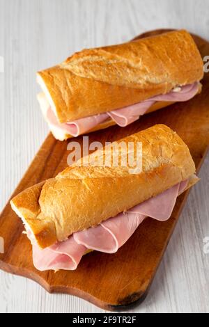 Homemade Parisian Jambon-Beurre Sandwich on a rustic wooden board, low angle view. Stock Photo