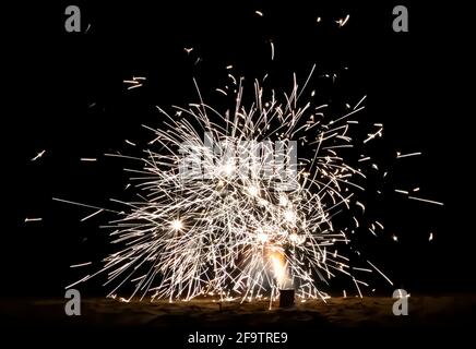 Close up fireworks on a beach at night with explosions of light on a black background. Stock Photo
