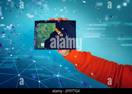 Man holds an hard disk. concept of storage and memory. cyan background Stock Photo