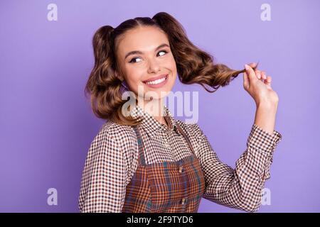 Photo of gorgeous young lady hand fingers playing with hair look empty space isolated on violet color background Stock Photo