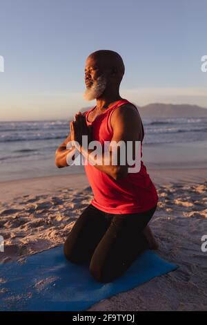 African Man Doing Yoga Online Meditating Sitting At Laptop Indoor