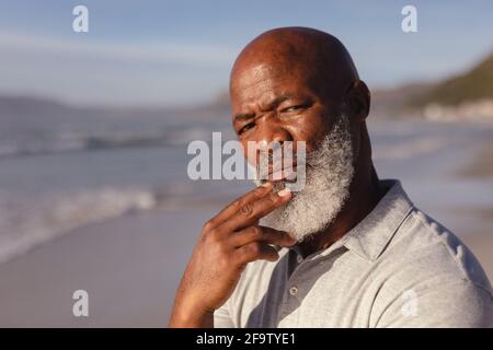Close up of thoughtful senior african american man standing on the beach Stock Photo