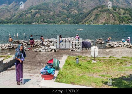 SANTIAGO ATITLAN, GUATEMALA - MARCH 24, 2016: Local indigenous women wash laundry in Atitlaan lake in Santiago Atitlan village.