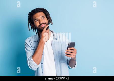 Portrait of attractive minded guy using gadget creating new post media comment isolated over bright blue color background Stock Photo