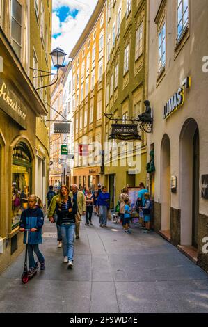 SALZBURG, AUSTRIA, JULY 3, 2016: People are strolling on the Getreidegasse street in the Austrian city Salzburg. Stock Photo