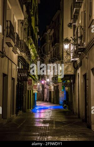VALENCIA, SPAIN, DECEMBER 31, 2015: people are walking through a narrow street in the old town center of spanish city valencia. Stock Photo