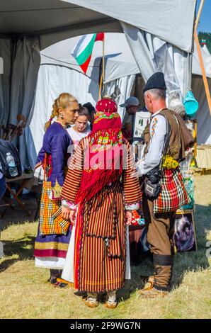 ROZHEN, BULGARIA, JULY 18, 2015: Women dressed in traditional bulgarian dresses are selling souvenirs during rozhen folklore festival near chepelare. Stock Photo