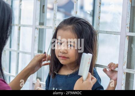 Closeup shot of a cute Southeast Asian baby girl staring with her big black eyes Stock Photo