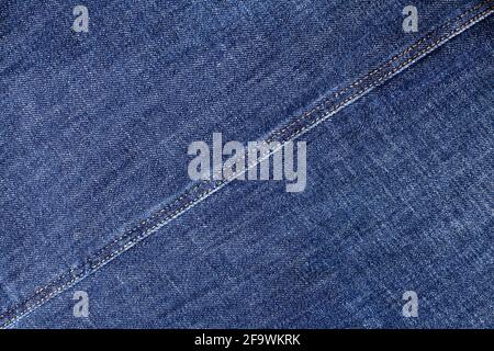Blue jeans texture, diagonal seam closeup, thread stitch line, jean textile background, dark blue denim backdrop, jeans pattern, indigo jeans cloth Stock Photo