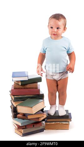 Boy stands on stack of books for educational portrait - isolated over white background Stock Photo