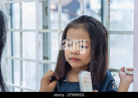 Closeup shot of a cute Southeast Asian baby girl staring with her big black eyes Stock Photo