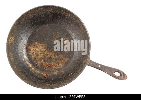old disgusting stained rusty cast iron pan with burnt fat isolated in directly above perspective. Stock Photo