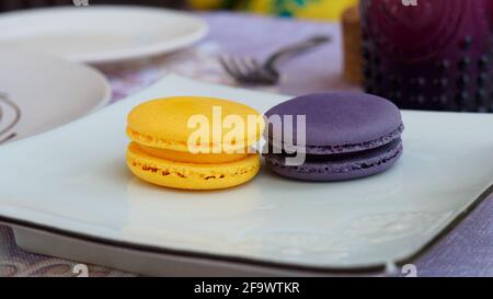 Yellow and violet Macaron or French Macaron, sweet confection introduced since 19th century. Stock Photo