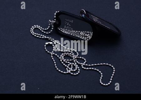 Shiny Blank Metallic Military Identification Plate on dark Background Stock Photo