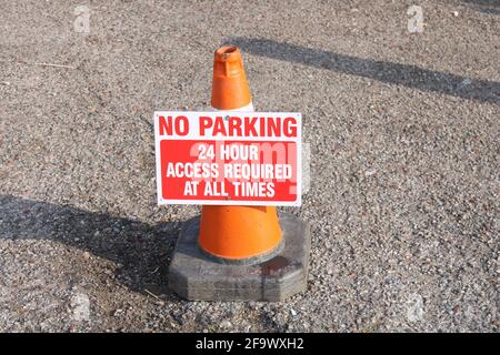 No parking 24 hour access required at all times sign attached to a traffic cone Stock Photo