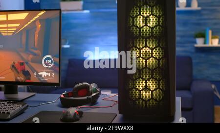 Close-up of RGB system desktop, pro gamer playing first person shooter video game during online competition. Streaming studio is equipped with professional setup with powerful pc ready for online game Stock Photo