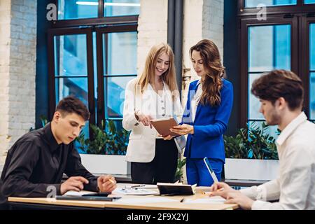Businesswomen and businessmen working in office Stock Photo