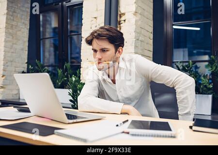 Focused businessman working on laptop in office Stock Photo