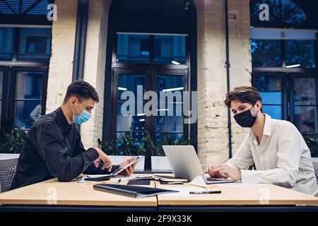 Businessmen in medical masks working in office Stock Photo