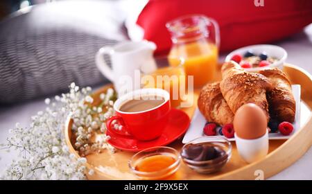 A tray with breakfast on a bed in a hotel room. Stock Photo