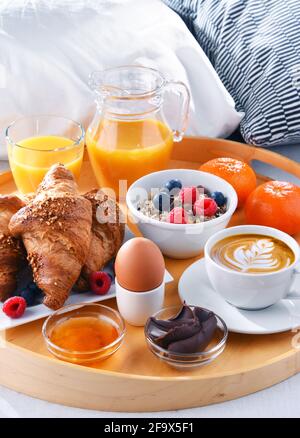 A tray with breakfast on a bed in a hotel room. Stock Photo