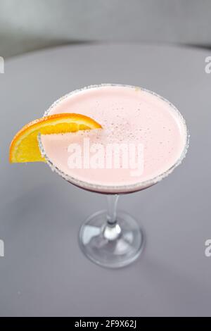 red cocktail with orange on a gray background. Stock Photo