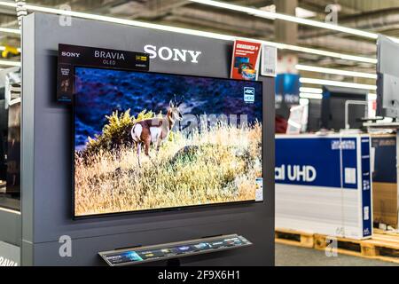 POZNAN, POL - FEB 24, 2021: Modern flat-screen TV set by Sony put up for sale in an electronics store Stock Photo