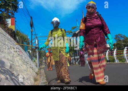 Padang, Indonesia. 21st Apr, 2021. Volunteers wearing protective suits spray disinfectant in public area amid the COVID-19 outbreak as part of the commemoration of Kartini Day in Padang, West Sumatra, Indonesia, April 21, 2021. Kartini Day is commemorated on April 21 every year to mark the birth of Raden Ajeng Kartini, an Indonesian national heroine born in 1879 who pioneered in the area of women's rights. Credit: Vivi Hutagalung/Xinhua/Alamy Live News Stock Photo