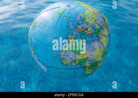 Plastic, inflatable globe floating in a swimming pool. Close up. Stock Photo