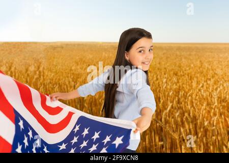 Little kid with the American flag on his back Stock Photo