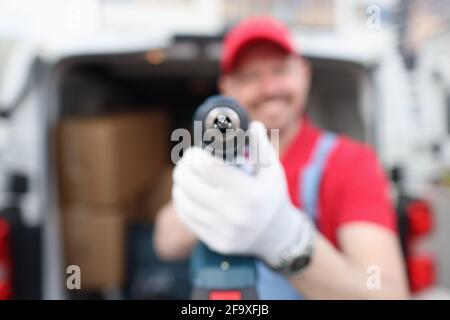 Smiling male master builder holding drill closeup Stock Photo