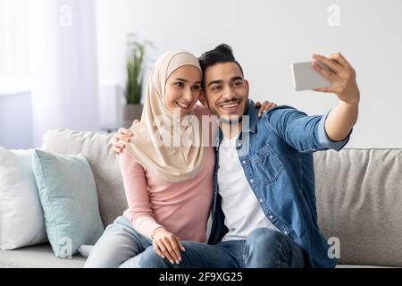 Beautiful arab couple taking selfie on mobile phone Stock Photo