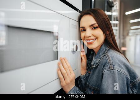 Young woman selected a new microwave oven in hypermarket Stock Photo