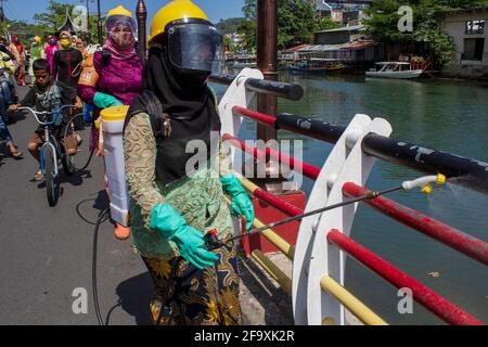 Padang, Indonesia, 21st April 2021. Women in Indonesia, Padang City, West Sumatra province wear the Kebaya to celebrate Kartini Day and spraying disinfectants on public roads in Batang Arau Village. Kariadil Harefa. Stock Photo