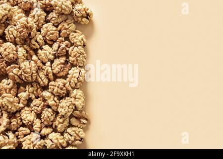 Frame of fresh walnuts without shells on beige background. Food walnuts border with copy space. Stock Photo