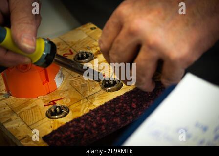 Hands of a man soldering cables to audio connector sockets Stock Photo