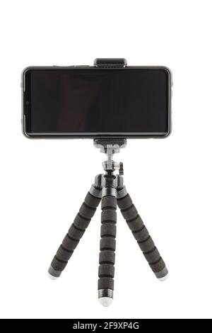 black cellphone in rugged rubber protective cover on small flexible tripod isolated on white background Stock Photo