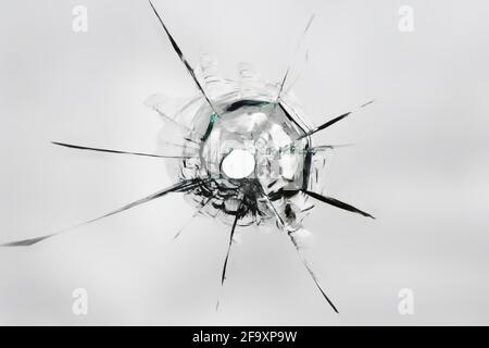 The texture of the hole from the shot on the glass. Cracked broken window. Stock Photo