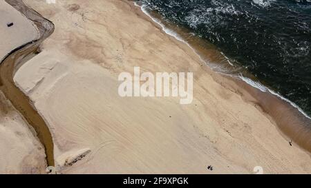 Aerial Drone Top View - Small Stream and Golden Sand in the Beach - Porto, Portugal Stock Photo