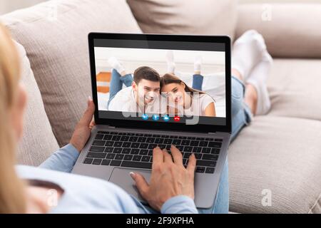 Online Call. Woman Sitting On Couch With Laptop Video Chatting With Friends Stock Photo