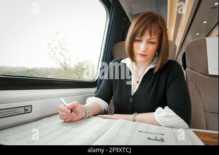 Young woman travelling on a train in the UK. Stock Photo