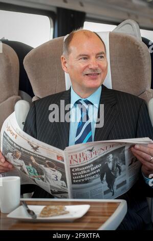Business man travelling on a train in the UK. Stock Photo