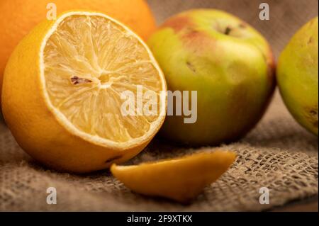 Sliced lemon and fresh green apples on a homespun cloth with a rough texture. Close-up selective focus. Stock Photo