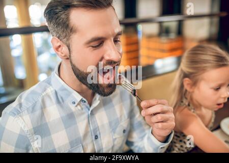 Bearded young man having breakfast with his family Stock Photo