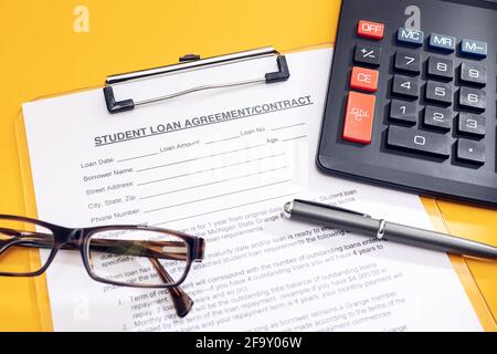 Blank Student Loan Application, calculator, pen and eyeglasses on table. Education cost concept Stock Photo